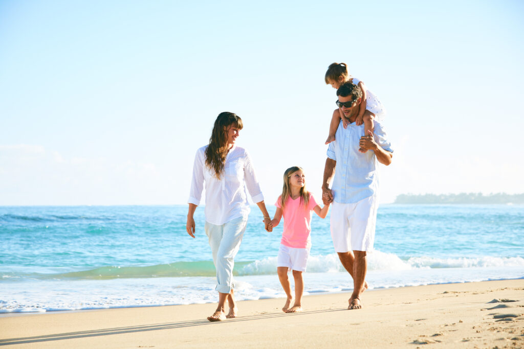 Happy family enjoying walk on the beach