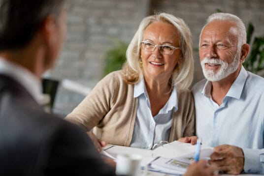 Happy senior couple having a meeting with real estate agent.