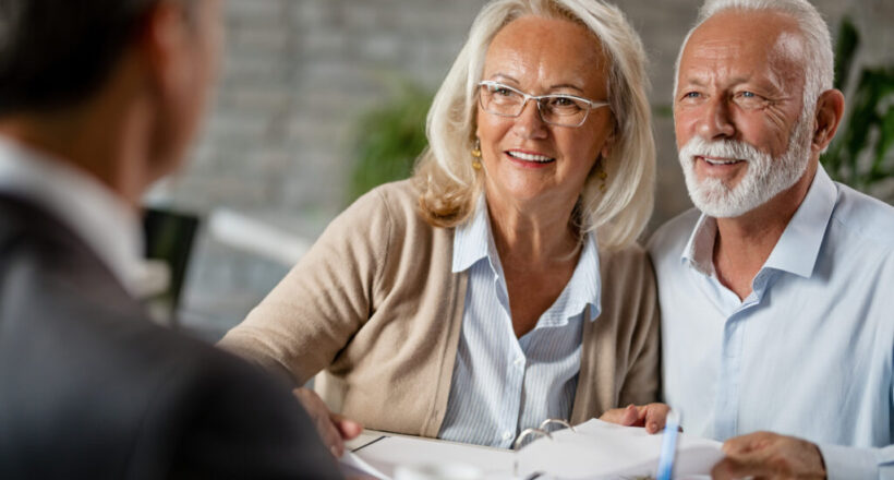 Happy senior couple having a meeting with real estate agent.