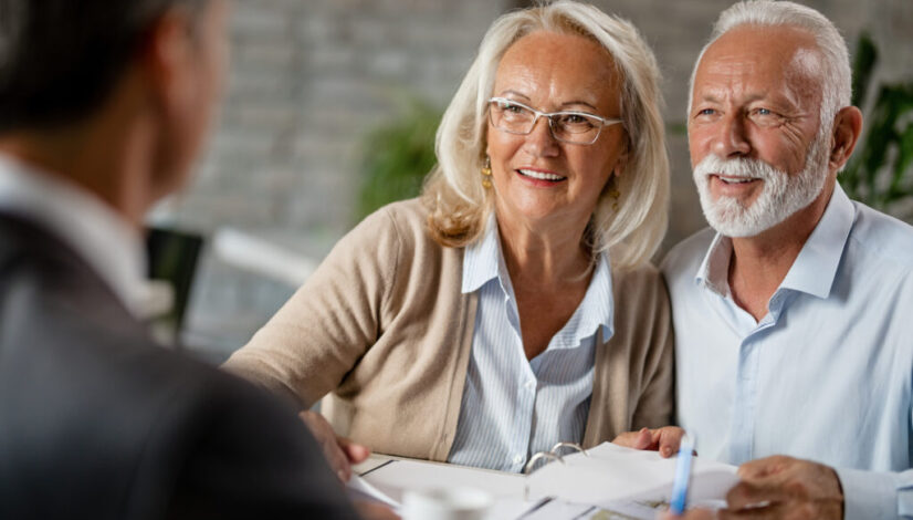 Happy senior couple having a meeting with real estate agent.